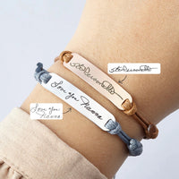 Handwriting bracelet shown on a wrist, engraved with a signature and message.