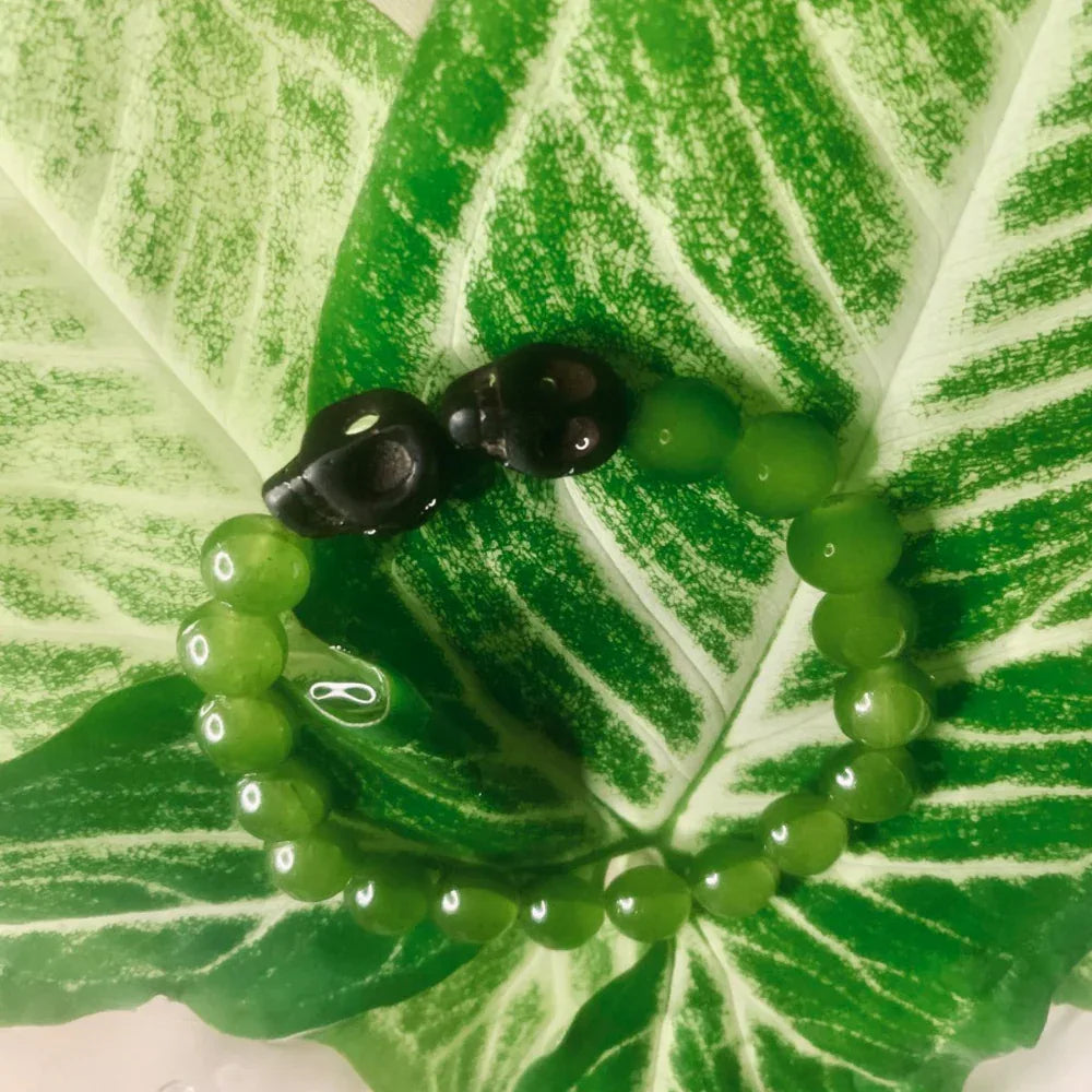 Stretch bracelet featuring assorted green gemstone beads in bohemian style on elastic cord.