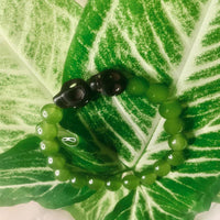 Stretch bracelet featuring assorted green gemstone beads in bohemian style on elastic cord.