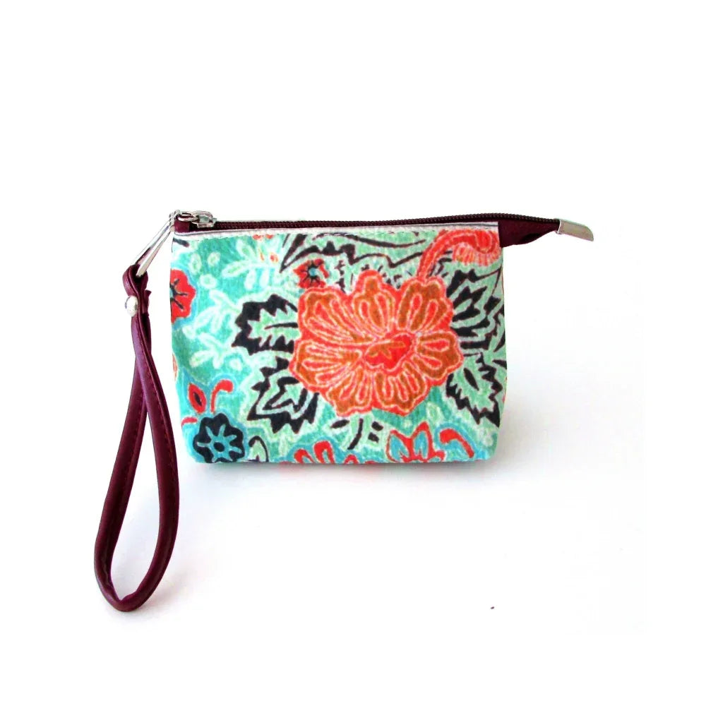 Red wristlet bag placed flat, highlighting its compact size and detailed pattern artwork.