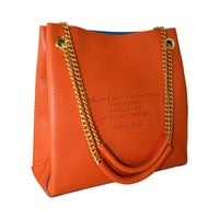 Burgundy Loving Handbag with engraved poem on leather surface and shiny adjustable handles, styled elegantly.