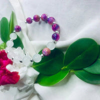 White and purple stone stretch bracelet laid flat showing smooth beads and metallic spacers.