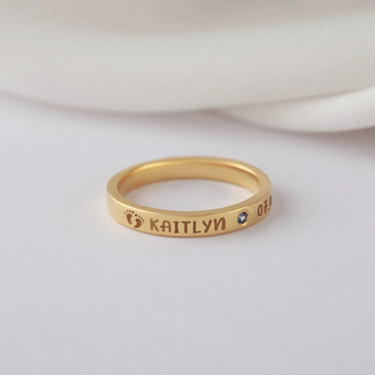 Close-up view of a silver ring with custom engravings, ideal as a new mom gift.