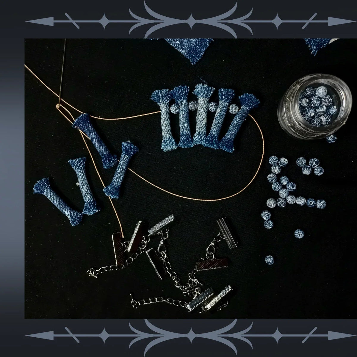 Overhead shot of denim tribal jewelry set with black lava and weathered agate stones on white surface.