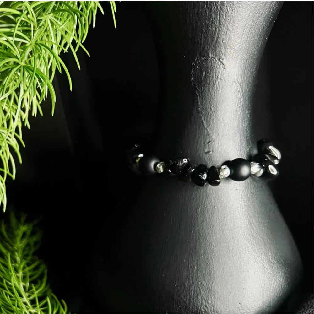 Black polished stone chip bracelet laid flat highlighting the irregular stone shapes.