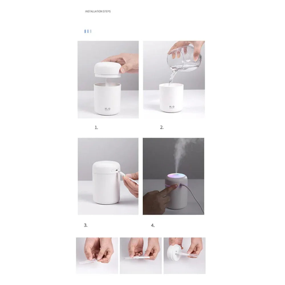 Small portable aroma diffuser connected via USB cable on office desk with laptop nearby.