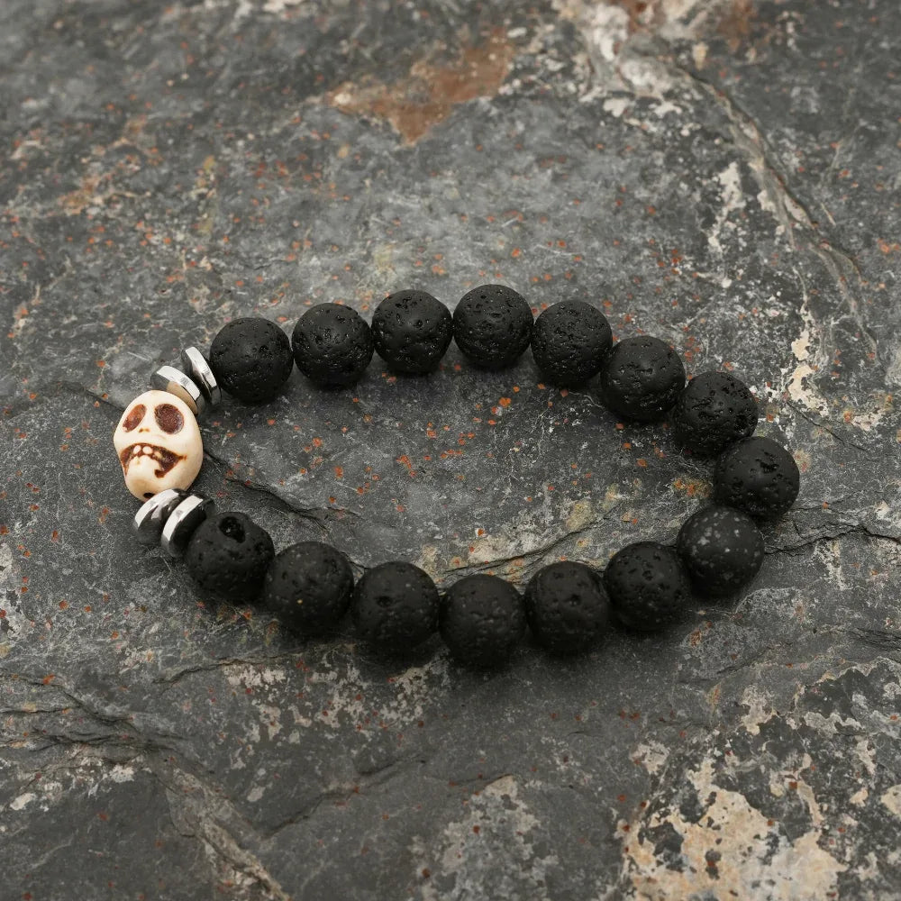 Close detail of silver skull bead surrounded by textured black lava stone beads on bracelet