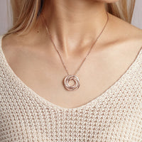 Stacked silver loop rings necklace worn on a person's neck, highlighting the personalized name engraving.