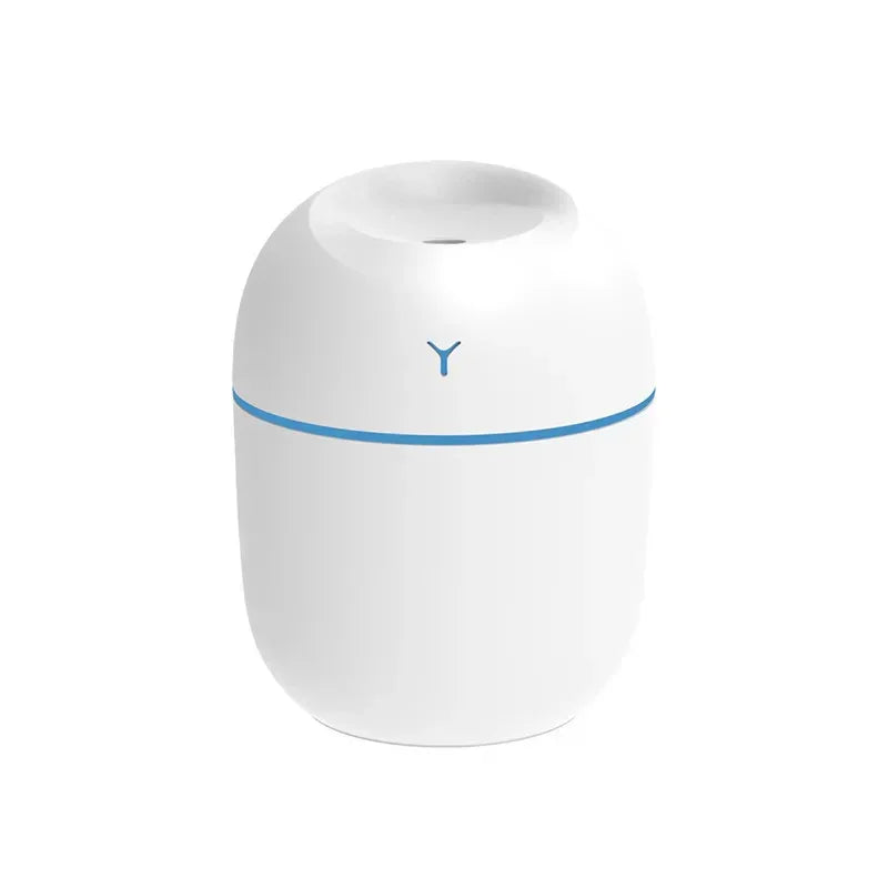 Hand holding pink portable USB ultrasonic humidifier with glowing LED light.