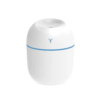 Hand holding pink portable USB ultrasonic humidifier with glowing LED light.