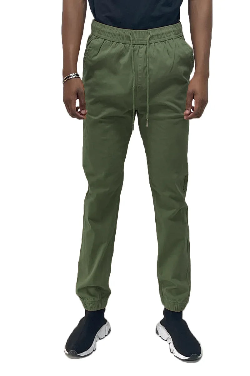 Side view of jogger pants showing elastic ankle cuffs and two back pockets in a neutral color.
