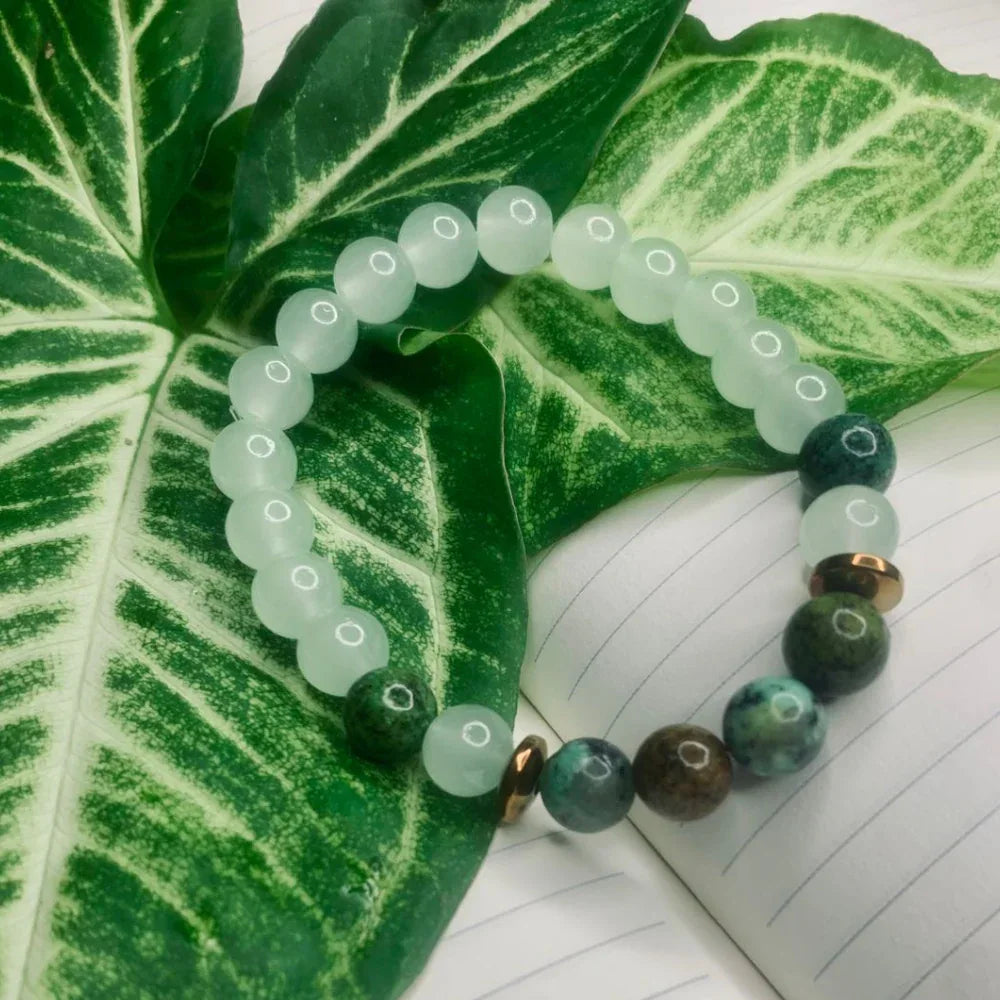 Green and white agate bead bracelet with copper spacers laid flat, highlighting bead details
