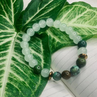 Green and white agate bead bracelet with copper spacers laid flat, highlighting bead details