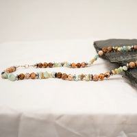 Close-up of multi-color natural agate stone necklace showing warm brown, cream, and green beads.