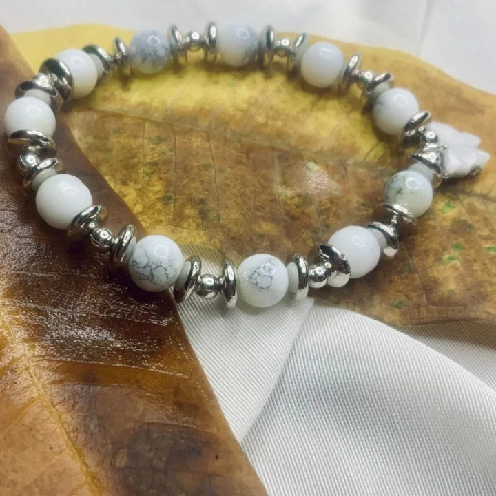 Dalmatian Jasper bead bracelet with black spots and silver spacer beads on a white background