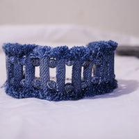 Close-up of denim tribal bracelet with lava and agate stones showing detailed stitching and texture.