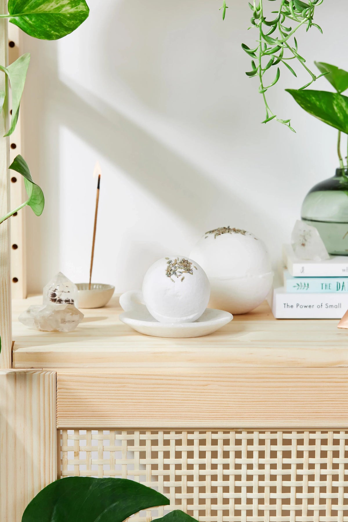 Two sizes of lavender bath bombs displayed with sprigs of fresh lavender nearby.