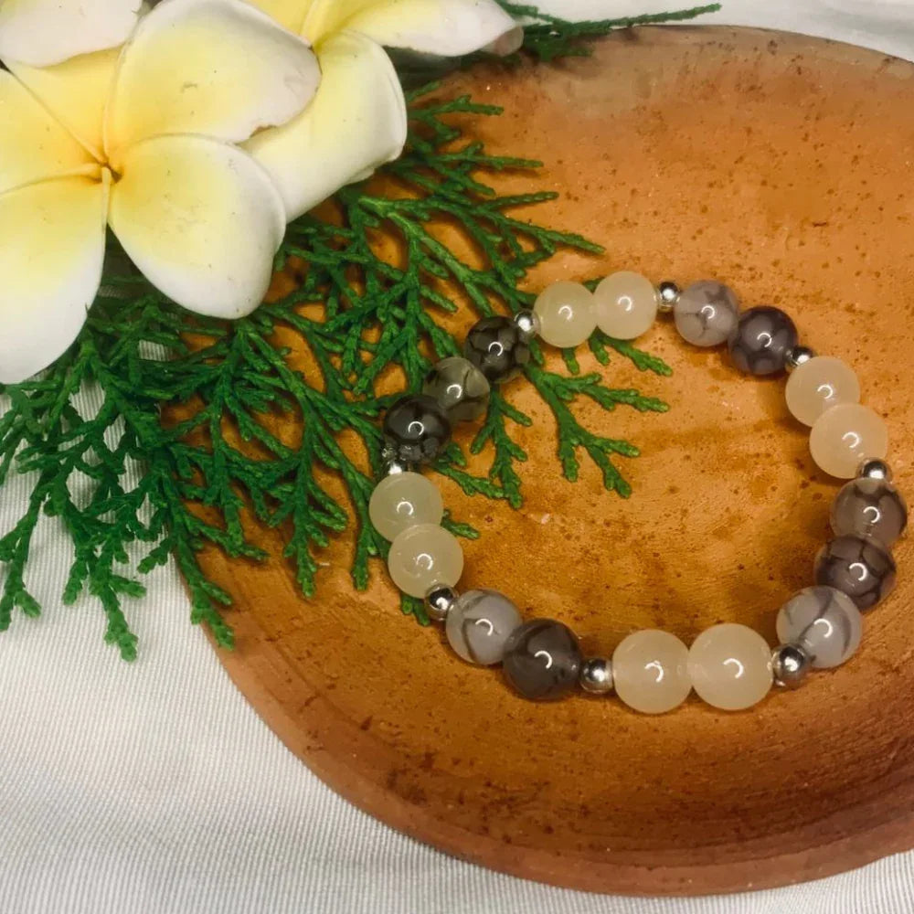 Detailed view of smooth gray and white agate beads with polished silver spacers.