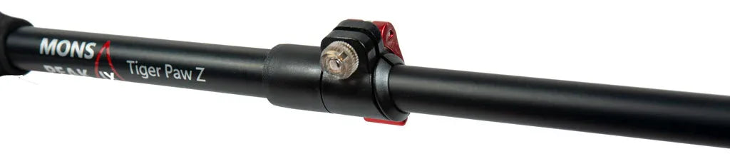 Set of black hiking trekking poles resting on rugged outdoor terrain.