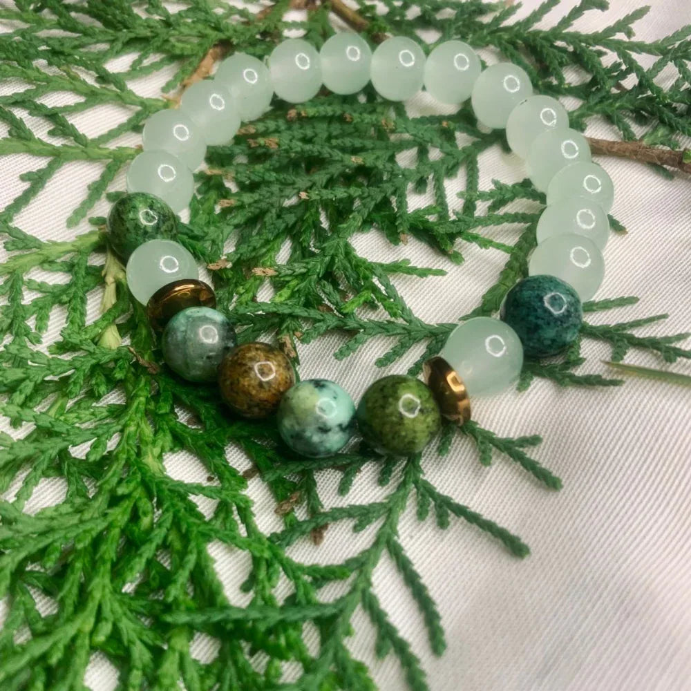 Close-up of green and white agate bead bracelet with copper spacers on white background