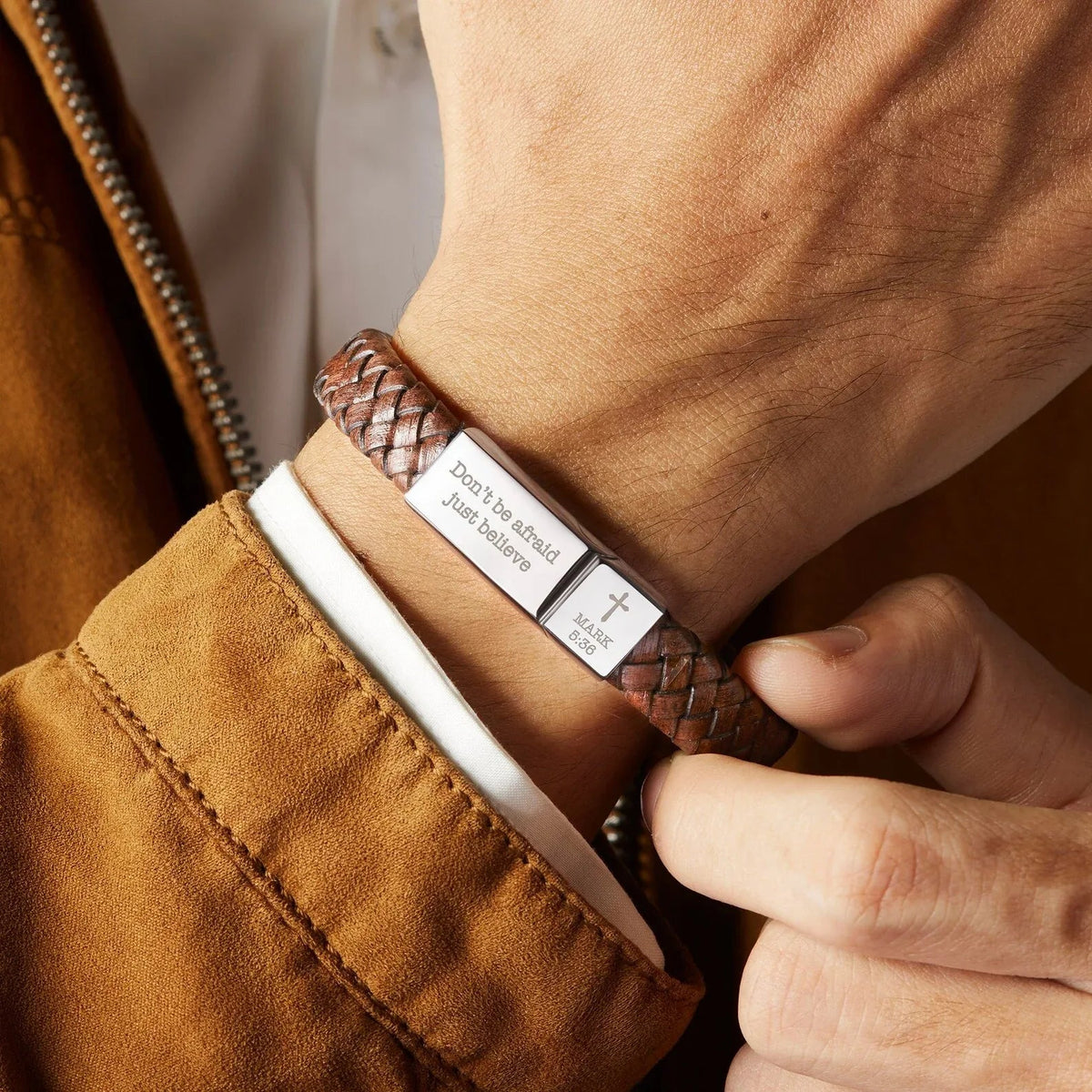 Side view of brown woven leather bracelet showcasing the stainless steel rectangular plate with engraved scripture.
