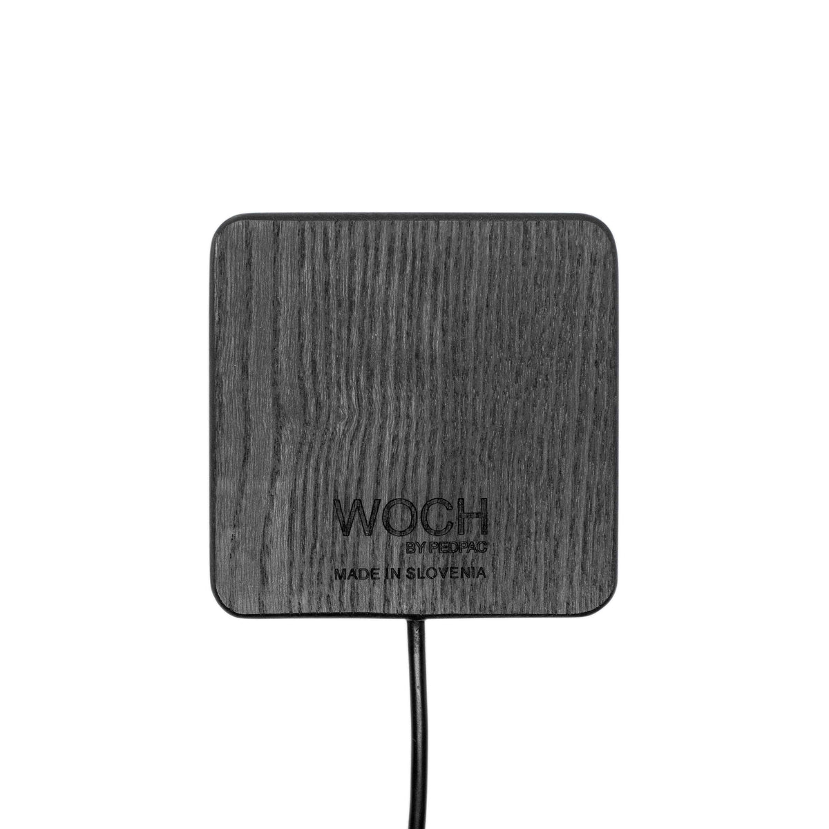 Handcrafted wooden wireless charger displayed with smartphone angled on top in natural setting