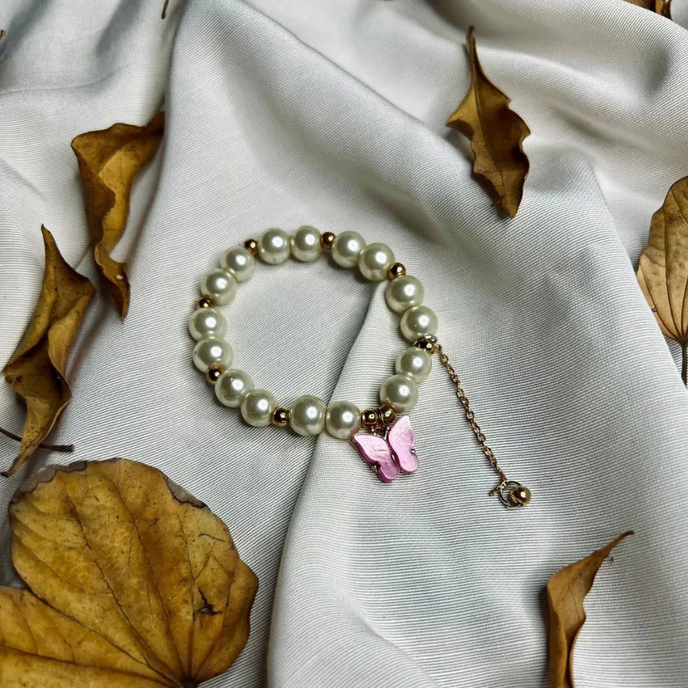 Elegant faux pearl bracelet featuring a purple butterfly pendant, suitable for girls