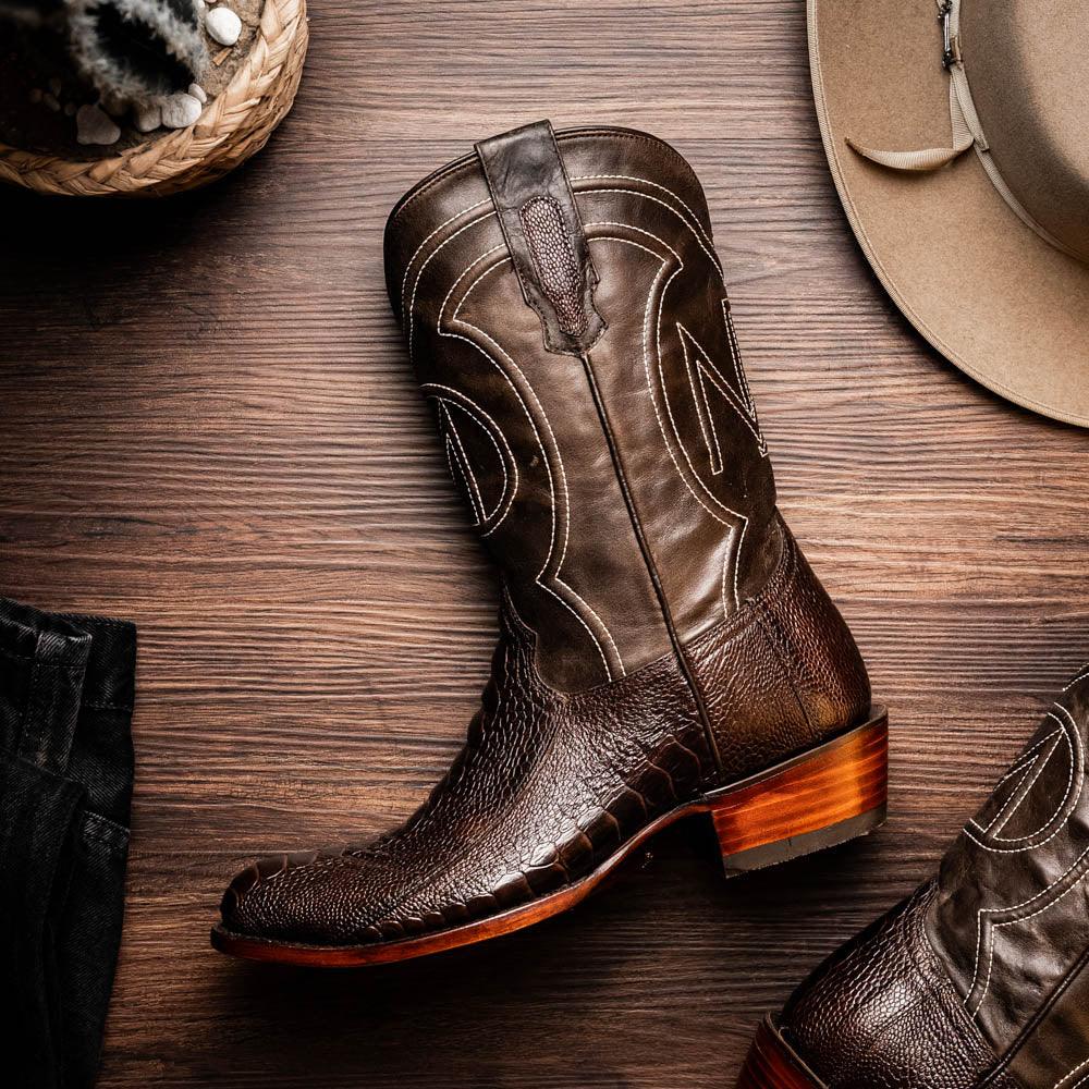 Close-up of western-style Denver boot with rich red vamp and black leather shaft outdoors.