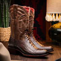 Lifestyle image of person wearing Denver Clear Brown ostrich leg cowboy boots outdoors on wooden steps.