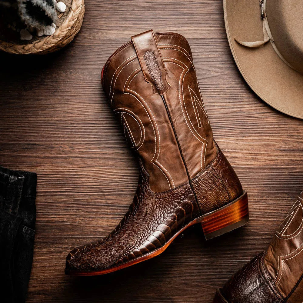 Denver Clear Brown ostrich leg skin boots shown in walking motion on rustic wooden surface.