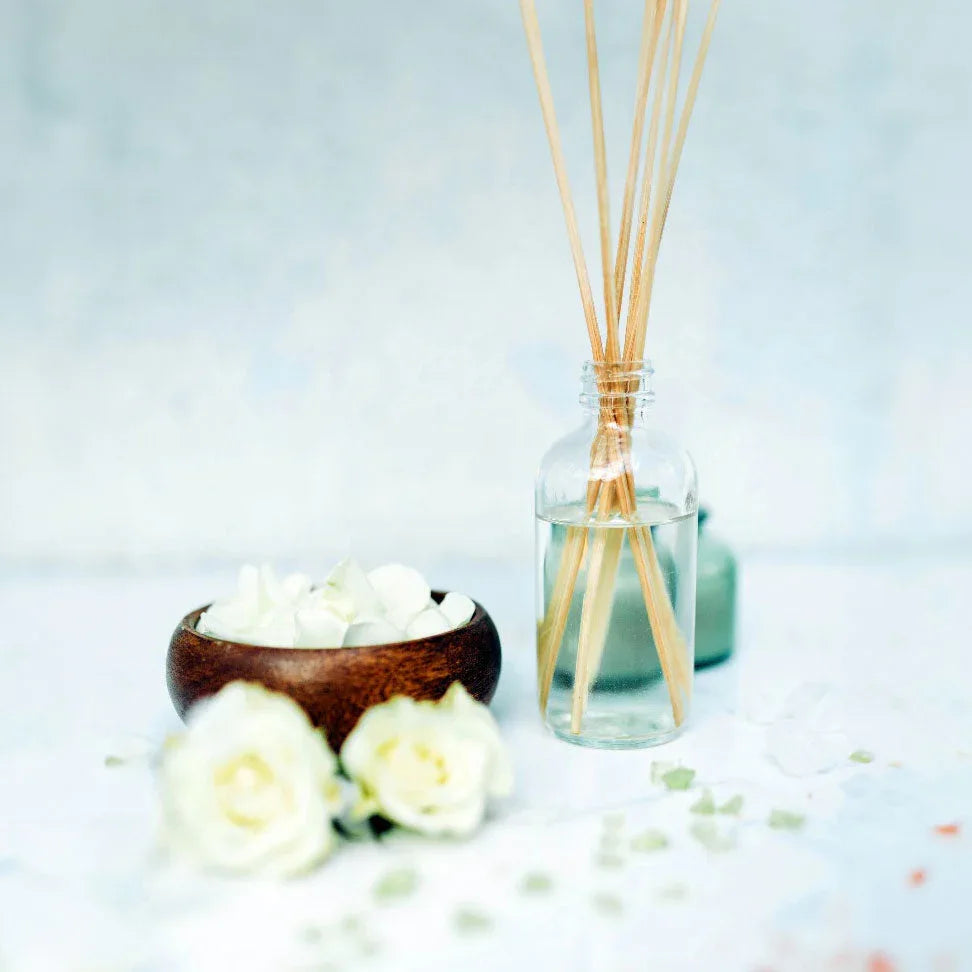 Living room setting with Passionate Fruit Reed Diffuser on a wooden table adding decor and fragrance.