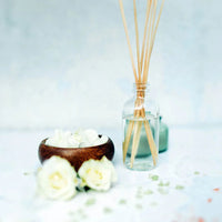 Living room setting with Passionate Fruit Reed Diffuser on a wooden table adding decor and fragrance.