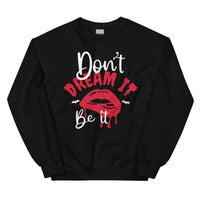 Black sweatshirt with 'Don't Dream It' text, cozy fleece material, adjustable banded cuffs.