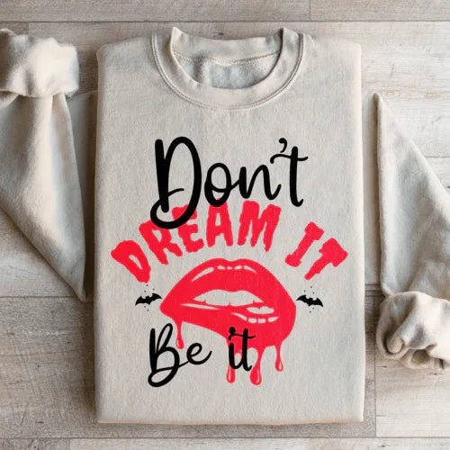 Peach-colored sweatshirt showing sleeve and part of 'Don't Dream It' print in white lettering.