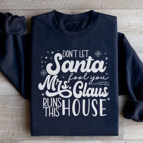 Black sweatshirt displaying 'Don't Let Santa Fool You Mrs Claus Run This House' slogan