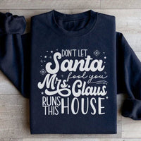 Black sweatshirt displaying 'Don't Let Santa Fool You Mrs Claus Run This House' slogan
