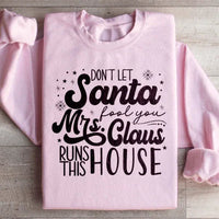 Light pink sweatshirt featuring 'Don't Let Santa Fool You Mrs Claus Run This House' graphic