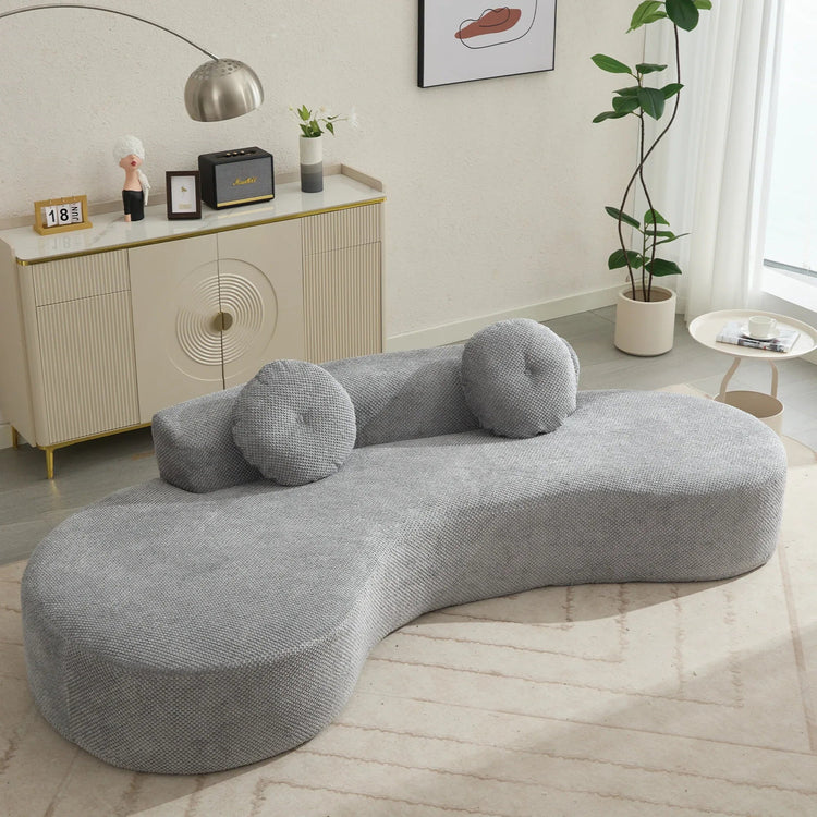 A modern gray curved sofa with plush cushions and upholstered polyester fabric, comfortably seating three people.