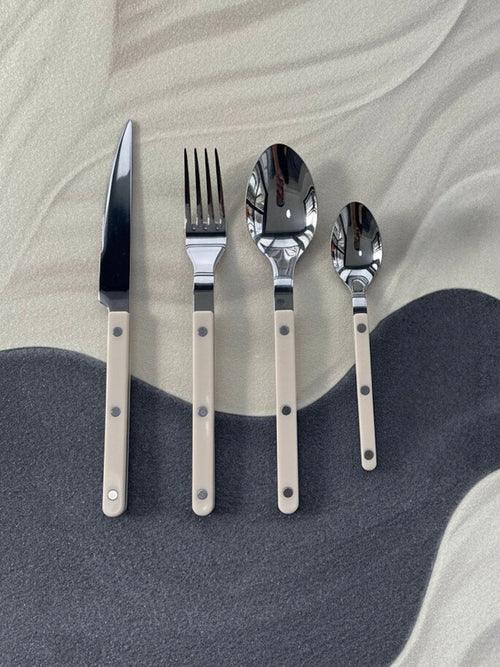 Elegant Nordic flatware set with ivory handles displayed next to a linen cloth and decorative tableware.