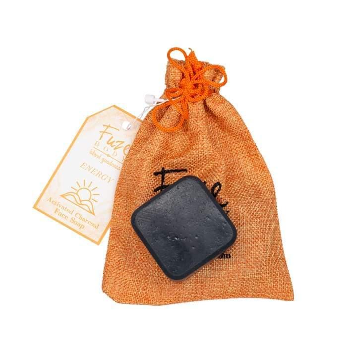 Energy Activated Charcoal Facial Soap with orange coin purse on a white surface