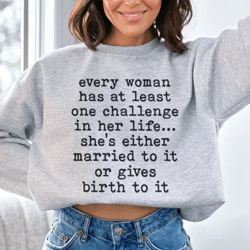 Sport grey sweatshirt with white bold text 'Every Woman Has At Least One Challenge In Life' on front.