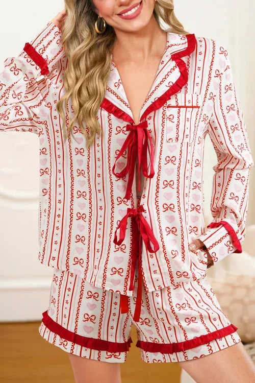 Full pajama set displayed on mannequin with floral, heart, and bow prints and ruffled edges.