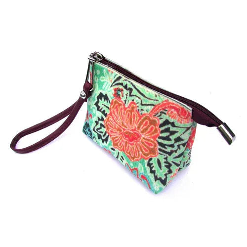 Red wristlet bag resting next to scattered coins, cards, and makeup items on table.