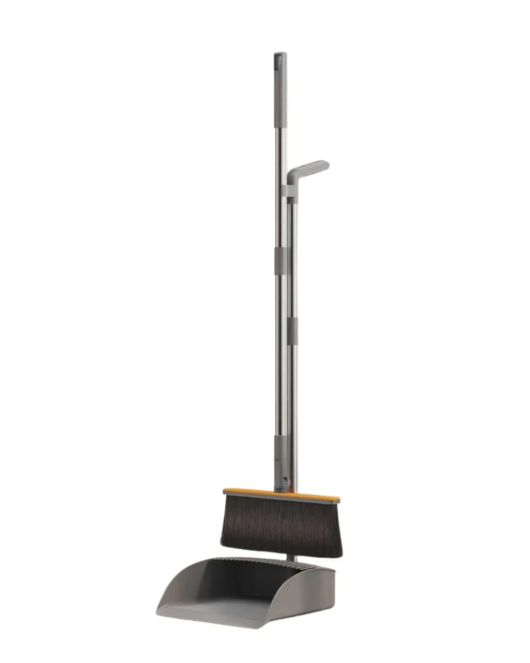 Foldable broom and dustpan set leaning against a wall with wooden floor background