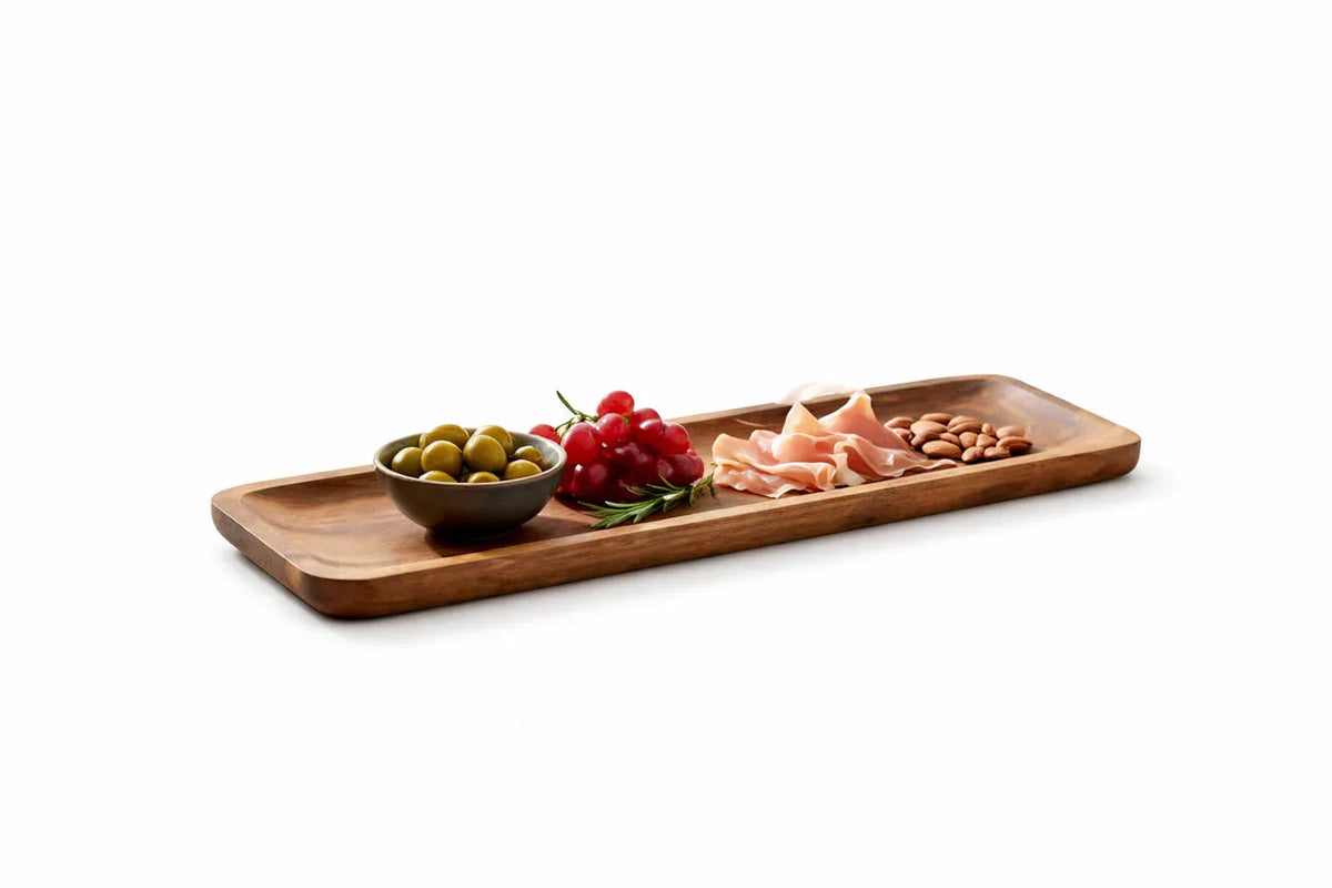 Long wooden appetizer serving platter with snacks on a rustic wooden table