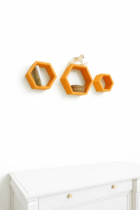 Set of 3 orange hexagon wall shelves mounted on white wall with decorative items