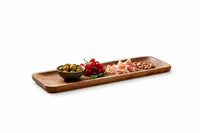 Long wooden appetizer serving platter with snacks on a rustic wooden table