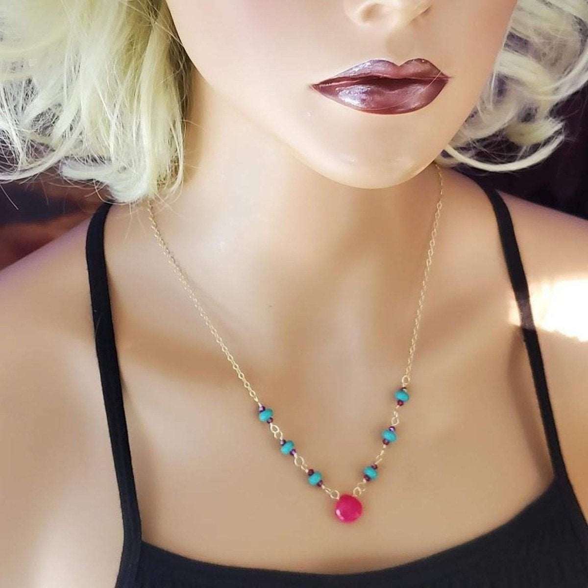 Elegant gold-filled necklace with interlinked turquoise and pink chalcedony gems on white background.