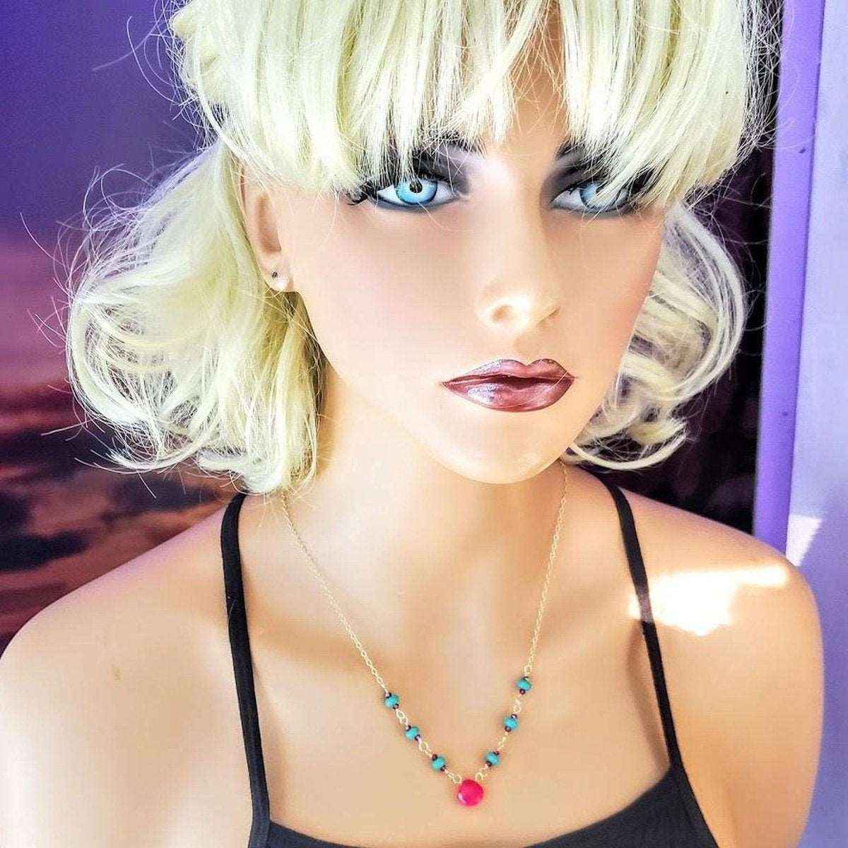 Close-up of 14K gold-filled necklace featuring turquoise and pink chalcedony gemstone links.