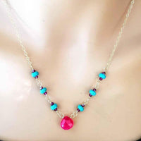 Detailed view of gold-filled necklace chain accented with turquoise and pink chalcedony gemstones.
